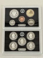 Photo of two plastic cases each containing six proof coins from 2017 US Mint Proof Set, including basic denominations and commemorative quarter series.