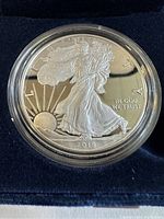 Close-up of the 2018 American Eagle silver proof coin showing the Walking Liberty design and inscriptions with coin encased in a clear protective capsule.