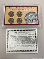Close-up image of four Buffalo Nickels in the display case to detail coin design and condition.