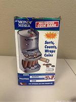 Front side of the Money Miser coin bank original box showing product image and features such as sorting, counting, and wrapping coins. Box shows wear and tear.