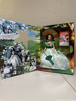 Barbie doll dressed as Scarlett O'Hara from Gone with the Wind in green and white gown inside the box showing movie images and backdrop.