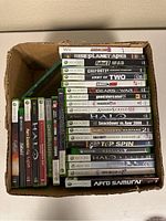 Photo showing boxed collection of 26 video games on Wii, Xbox 360, and Xbox One including well-known titles