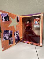 Open box showing Barbie doll in burgundy gown and Gone with the Wind movie poster inside.