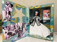 Barbie doll displayed in original box with background images and movie references