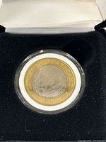 Close-up of the Pope John Paul II 1,000 Lire coin in a clear protective case showing detailed portrait and inscriptions.