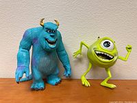 Front view of Sully and Mike figure toys from Monsters Inc., showing detailed colors and poses.