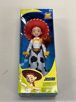Front of the box showing Jessie doll in cowgirl outfit visible through clear window, with Toy Story branding and artwork.