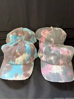 Four ponytail hats: two blue and two pink with distressed design, placed in two rows to show front view and color variations.