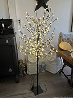 Full view of 48 inch cherry blossom tree lighted decoration with black base indoors.