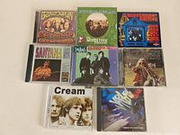 All eight 60's rock music CDs laid out on a flat surface showing front cover art for each album.