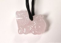Front view of pink quartz Foo Dog pendant on black cord.