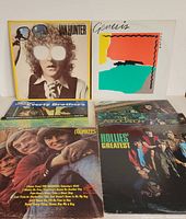 Five classic rock vinyl LP records laid out showing covers with various classic rock artists including Ian Hunter and Genesis.