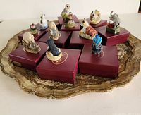Top view showing 12 animal figurines on maroon presentation boxes arranged on a decorative tray.