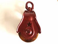 Barn pulley showing overall metal body and star-shaped cutout