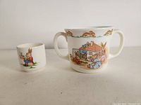 Two Royal Doulton Bunnykins fine bone china cups side by side showing bunny illustrations