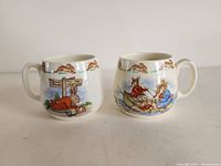 Two Royal Doulton Bunnykins fine bone china mugs with colorful bunny character designs on front and decorative running bunny border near rims.