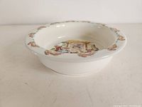 Photo showing one white bone china bowl with Bunnykins rabbits in a scene inside and bunny border around rim
