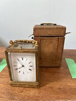 Clock and carrying case side by side on table