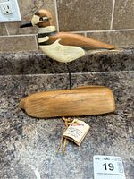 Side view of the Killdeer wood carving showing detailed paintwork and natural wood base with tag attached