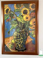 Framed print of sunflowers in a decorative vase with vibrant colors.