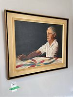 Full view of framed oil painting featuring elderly woman and quilt