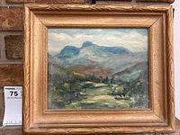 Framed oil on board painting showing landscape scene of Langdale Pikes mountains with green and blue tones under cloudy sky.