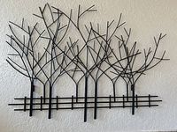 Full view of the metal wall decor mounted on a textured wall.