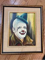 Framed oil painting of clown by Muriel Millard, signed lower right, showing full artwork and frame with some staining on matting.