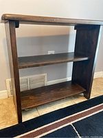 Front view of the pine bookshelf showing two open shelves and visible wood grain with minor wear.