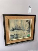 Framed winter scene watercolour painting hung on wall, showing soft muted snowy landscape and trees.