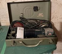 Walter grinder set inside green metal carrying case with power cord and multiple grinding/sanding discs.