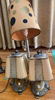 Photo showing the standing lamp with spotted lampshade and the pair of tan stitched sconces.