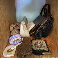 Photo showing multiple vintage purses and accessories together on wooden shelf.
