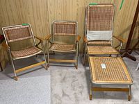 Three folding wicker chairs: two standard and one chaise lounge, shown together