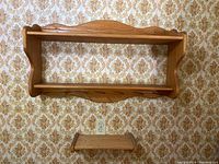 Photo of two wooden wall shelves mounted on patterned wallpaper wall showing size and style