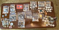 Overview of all sealed bags and loose coins spread on table