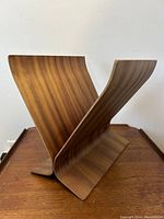Bentwood magazine rack angled side view showing the smooth bent wood and V shape.
