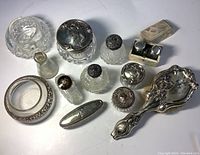 Overview of all vanity items including brush, jars, bottles and boxes on white background