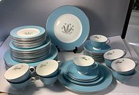 Full view of stacked plates alongside cups and saucers