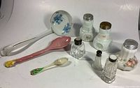 View of three porcelain ladles and six salt shakers, including crystal/glass shakers with sterling tops and early milk glass floral shakers