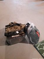 Two sets: one folded comforter in a plastic bag with snake-skin pattern and black stripe, and one bag with pillow cases beside it