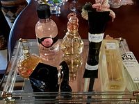 Mirrored tray with six perfume/shower gel bottles of varied shapes and brands