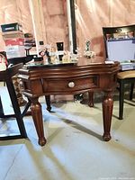 Side view of the Fairmont wooden side table showing front drawer, carved legs and dark wood finish