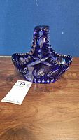 Front view of cobalt blue cut crystal glass basket showing leaf and diamond patterns with a handle.