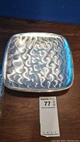 Top view of the pearlized silver footed tray showing the textured swirled surface pattern.