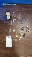 All jewelry items displayed on table including necklaces, bracelets, pendants, pin, and single earring