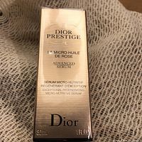 Front view of the sealed gold-tone box showing the product name and details in black and gold text.