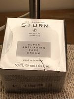 Front of sealed silver box showing brand, product name, net volume