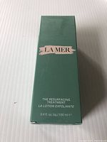 Front view of the green box with La Mer branding and product name The Resurfacing Treatment La Lotion Exfoliante, volume 3.4 fl oz (100 ml).