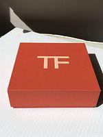 Closed matte orange box front with large TF logo